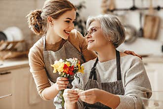 Happy mother`s day! family old grandmother  mother-in-law and daughter-in-law daughter congratulate on   holiday, give flowers