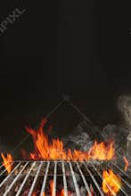 Hot empty portable summer barbecue BBQ grill with bright flaming fire and ember charcoal on black background. Cookout