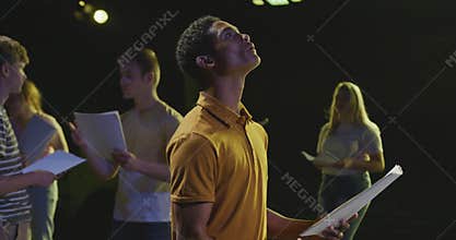 Students preparing before a high school performance in an empty school theater