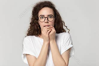 Young stressed fearful woman in eyewear feeling awe.