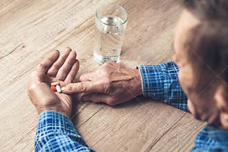 Many multi-colored pills in a Senior`s hands