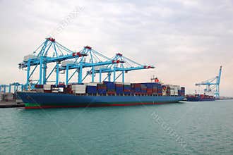 Cargo boat and barge docked to industrial port