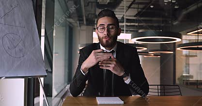 Smiling pleasant middle eastern ethnicity male speaker recording educational video.