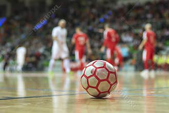 Close up of futsal ball with players in the background