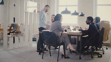 Dolly shot of happy business partners discussion in modern office. Multiethnic bosses collaborate on business project 4K
