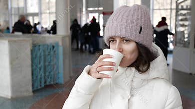 Young woman drinking mineral water from a paper Cup