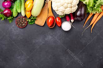 Fresh farmers garden vegetables and kitchen utensils on stone background. Harvest time. Top view