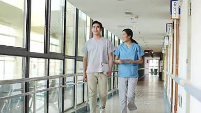 Two asian healthcare professional walking talking in hallway of medical facility