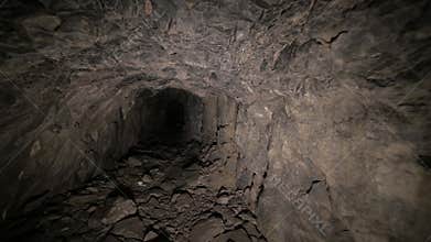 Flashlight illuminates dark passage in cave. Graffiti. Old abandoned mine.