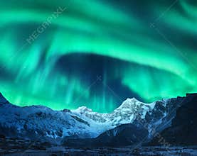 Aurora borealis above snow covered mountain range in europe
