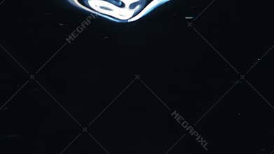 Close up macro of spoon mix stirring water. Bubble in liquid slow motion on black background.