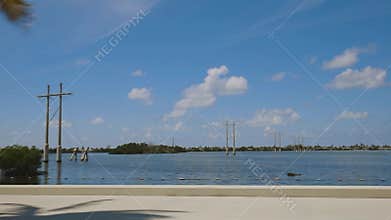 Highway to Key West Florida. View of old abandoned bridge and coast line of Atlantic ocean on blue sky.