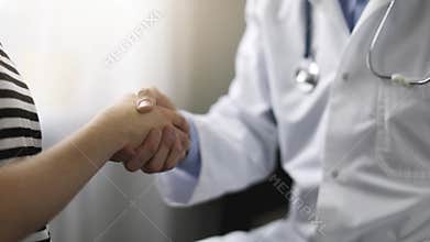 Doctor and patient handshake after visit in clinic office