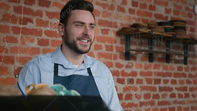 Smiling friendly caucasian man waiter professional barista bartender cafe staff in apron taking order at cafeteria