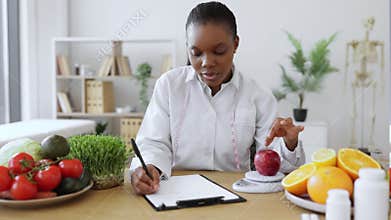 Professional assessing apple on scales in consulting room