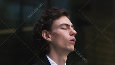Close up of stressed and upset and tired caucasian man outdoor near modern office. Portrait of businessman receiving
