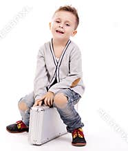 Cute boy sitting on luggage
