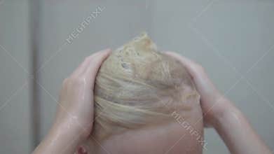 Close-up, a boy washes his white hair with shampoo