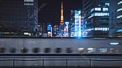 High speed rapid Shinkansen train transport in Tokyo at night, Tokyo tower cityscape view. Japanese commuter lifestyle