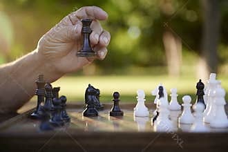 Active retired people, senior man playing chess at park
