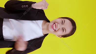 Portrait beautiful businesswoman in suit standing with glad and success isolated on yellow background.