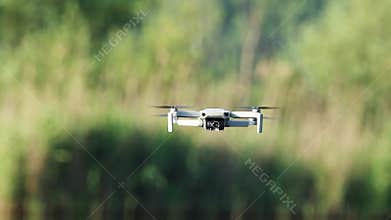 Dji Mini 2 drone, hovering in green summer nature