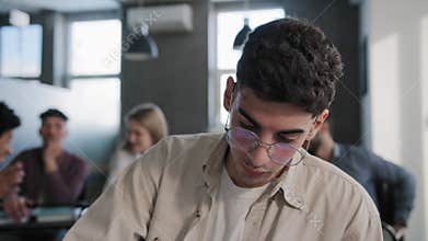Close-up young depressed student sitting in classroom at desk alone feeling frustrated stress unhappy sad guy nerd