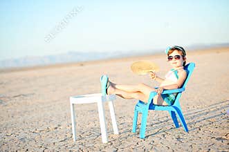 Little Girl In Bathing Suit With Fan In Hot Desert