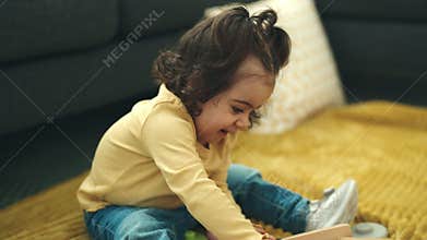Adorable hispanic girl playing with abacus sitting on sofa at home