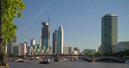 Boats on the River Thames, the city skyline and red buses on Lambeth Bridge, London, England