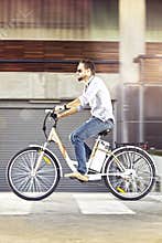 Young man riding electric bicycle