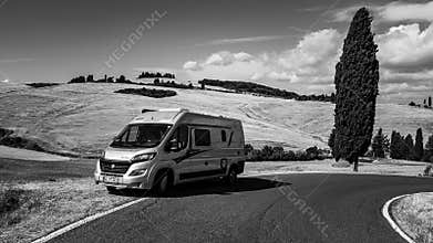 camper van on road against hill in Tuscany Italy