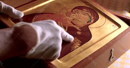 Close-up of hands of religious scholar talking about symbols depicted on icon