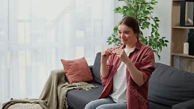 Overjoyed Young Woman Holding Pregnancy Test Stick Sitting on Sofa at Home. Pregnant Lady Surprised and Happy Expecting