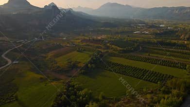 aerial scenic landscape with green fields, meadows, curved mountain river and mountain ridge with high mountains and