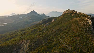 aerial scenic landscape with green fields, meadows, curved mountain river and mountain ridge with high mountains and