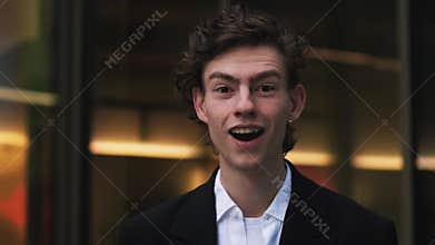 Surprised man looking at camera in slow motion. Handsome guy with wow expression. Close up young man posing outdoor near