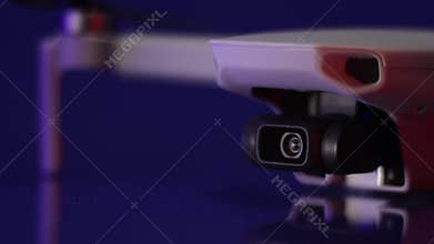 Plane detail of drone camera while it is turned on and makes its automatic calibration with dim lighting and blue and orange