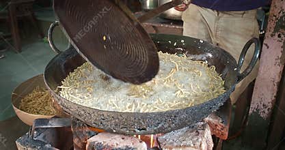Indian street food Murukku cooking in Rajasthan. Deep fried tasty vegetarian crispy snack in oilPushkar, India