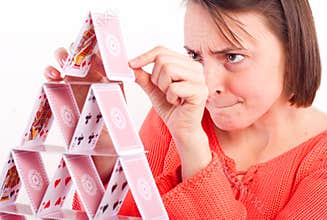 Attractive woman building house of cards