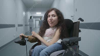 Woman with physical disability in wheelchair looks at camera