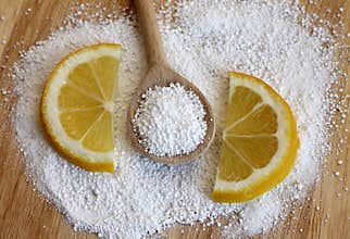 Citric acid in wooden spoon with lemon