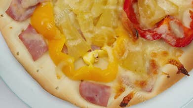 Top view closeup rotation of delicious homemade hawaiian pizza.