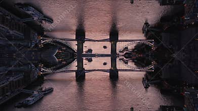 Aerial view of vehicles passing old Tower Bridge over River Thames in London at twilight. Abstract computer effect