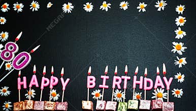 Happy birthday background with number  80. Copy space. Pink happy birthday candles on a black background. Happy birthday flower fr