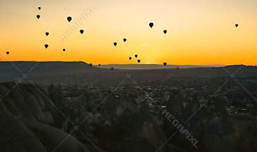 Early morning in the valley with rocks and balloons in the sky at dawn. Cappadocia. Turkey