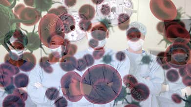 Animation of covid 19 cells over diverse surgeons wearing face masks in operating theatre