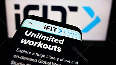 Smartphone with website of US fitness company iFIT Inc. on screen in front of business logo.