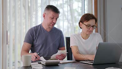 Woman and man with a dog together checking bills, taxes, bank account balance and calculating expenses in the living
