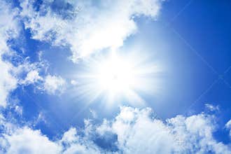 blue sky with sun, sunbeams and fragmented clouds.